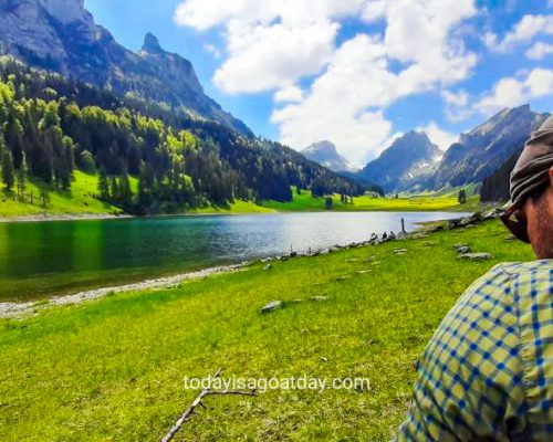 great hike in Appenzell, man overlooking green Sämtisersee, Alpstein