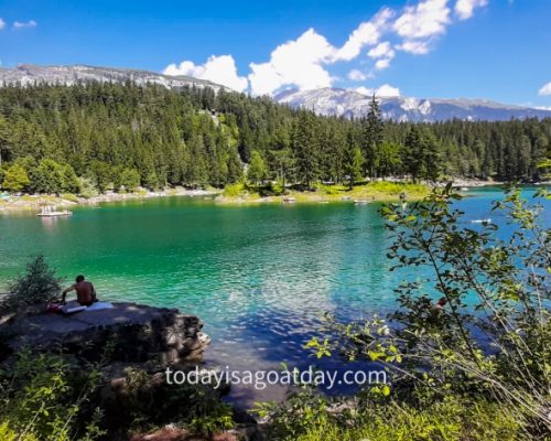 Hiking in Graubuenden, man sitting on a stone at the Caumasee