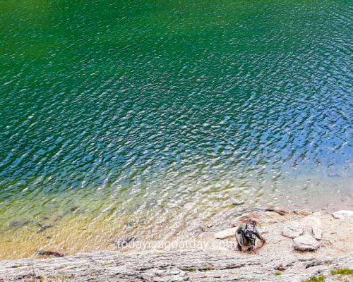 great hike in Appenzell, blue-green Sämtisersee, man playingg stone skippin