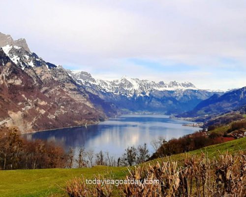 top hikes in glarus, view over green lake Walen, churfirsten range in the background