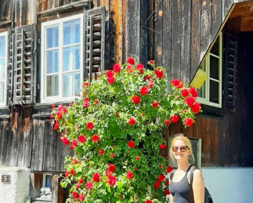 Hike in Central Switzerland, girls standing in front of Swiss chalet with red roses growing along the walls