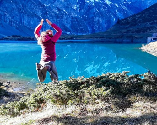 Hiking trails in Engelberg, woman jumping towards Trübsee