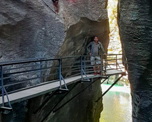 Man standing on a wooden gallery overlooking the river